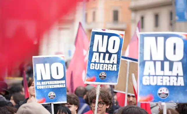 People hold banners reading 'No to war' as they take part in a national demonstration against the war in Iran and the March 22 referendum on the Italian justice system, in Rome, Saturday, March 14 2026. (AP Photo/Andrew Medichini)