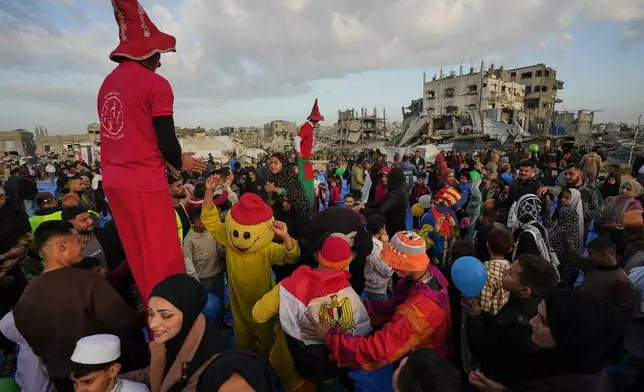Palestinians celebrate Eid al-Fitr amid the rubble of destroyed buildings in Jabaliya, Gaza Strip, Friday, March 20, 2026. (AP Photo/Jehad Alshrafi)