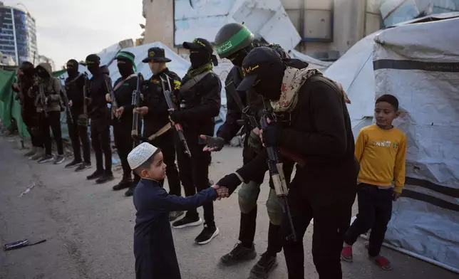 Palestinian militants from Hamas and Islamic Jihad greet people who gather for to Eid al-Fitr prayers in Gaza City, Friday, March 20, 2026. (AP Photo/Abdel Kareem Hana)