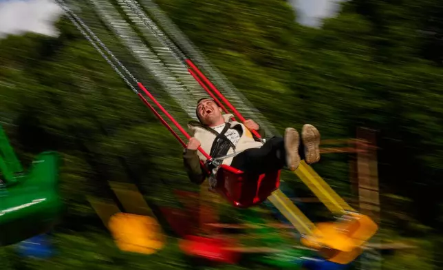 A young man enjoys a swing ride at an amusement park as he celebrates Eid al-Fitr, marking the end of the Muslim holy fasting month of Ramadan, in Beirut, Lebanon, Friday, March 20, 2026. (AP Photo/Hassan Ammar)