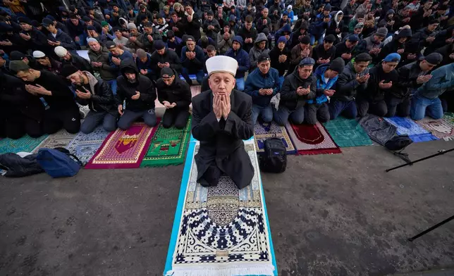 Muslims pray outside the Moscow Cathedral Mosque during celebrations of Eid al-Fitr holiday, a feast celebrated by Muslims worldwide, in Moscow, Russia, early Friday, March 20, 2026. (AP Photo/Alexander Zemlianichenko)