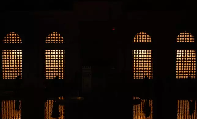 Muslim worshippers arrive to attend Eid al-Fitr prayers outside a mosque in Istanbul, Friday, March 20, 2026. (AP Photo/Khalil Hamra)