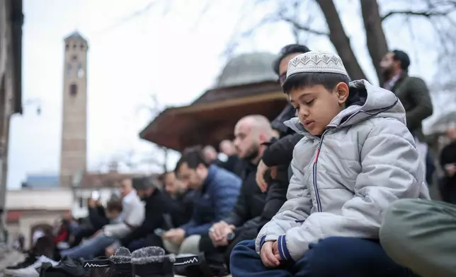 A Bosnian Muslim boy listens to a mufti delivering a sermon during Eid al-Fitr, which marks the end of the holy fasting month of Ramadan in Gazi Husrev-beg Mosque in Sarajevo, Bosnia, Friday, March 20, 2026. (AP Photo/Armin Durgut)