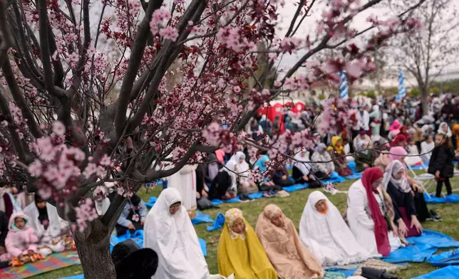 Muslim worshippers pray outside a mosque in Athens during celebrations of Eid al-Fitr, marking the end of the holy fasting month of Ramadan on Friday, March 20, 2026. (AP Photo/Petros Giannakouris)