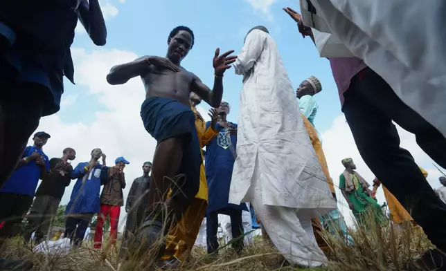 Young men sing and dance after Eid al-Fitr prayers, marking the end of the fasting month of Ramadan in Lagos, Nigeria, Friday, March 20, 2026. (AP Photo/Sunday Alamba)