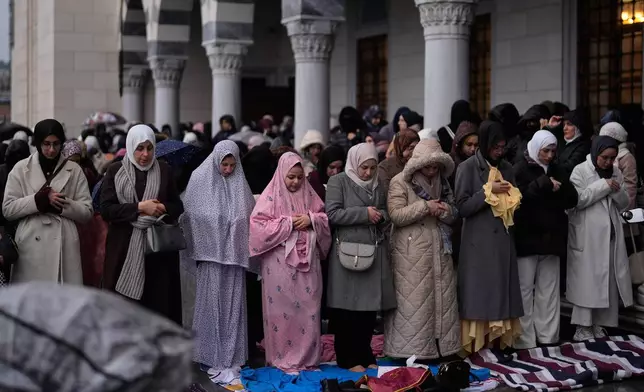 Muslim worshippers attend Eid al-Fitr prayers outside a mosque in Istanbul, Friday, March 20, 2026. (AP Photo/Khalil Hamra)