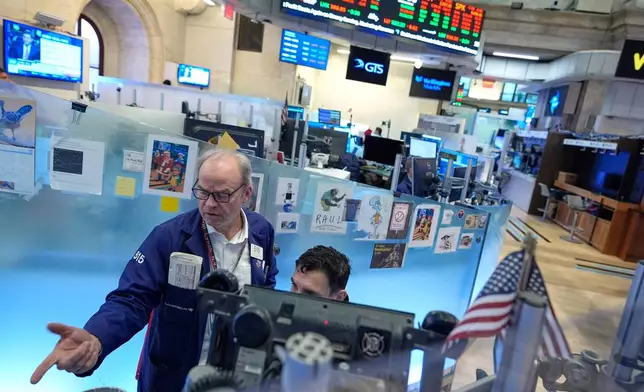 David O'Day, left, works on the floor at the New York Stock Exchange in New York, Wednesday, March 18, 2026. (AP Photo/Seth Wenig)