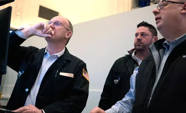 People work on the floor at the New York Stock Exchange in New York, Wednesday, March 18, 2026. (AP Photo/Seth Wenig)