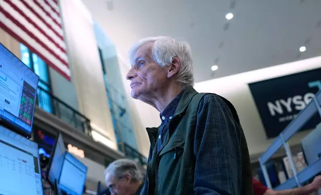 People work on the floor at the New York Stock Exchange in New York, Wednesday, March 18, 2026. (AP Photo/Seth Wenig)
