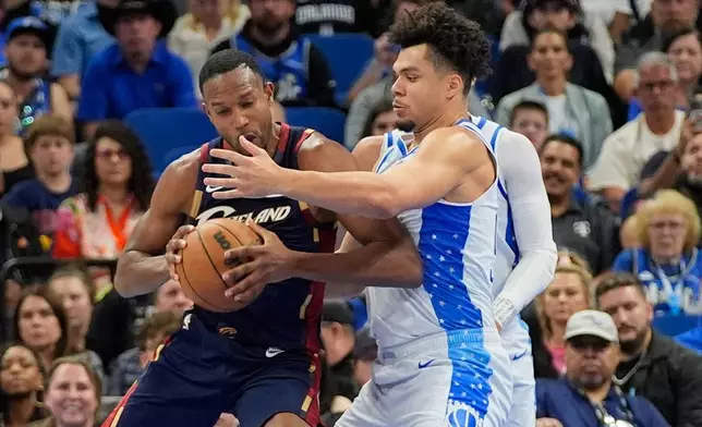 Cleveland Cavaliers center Evan Mobley, left, tries to get to the basket against Orlando Magic forward Noah Penda during the first half of an NBA basketball game, Wednesday, March 11, 2026, in Orlando, Fla. (AP Photo/John Raoux)