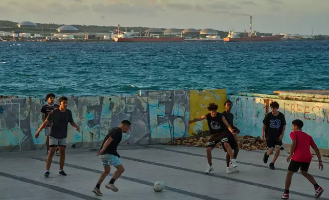 People play soccer in an abandoned swimming pool across from a tanker terminal along the port of Matanzas, Cuba, Monday, March 30, 2026. (AP Photo/Ramon Espinosa)