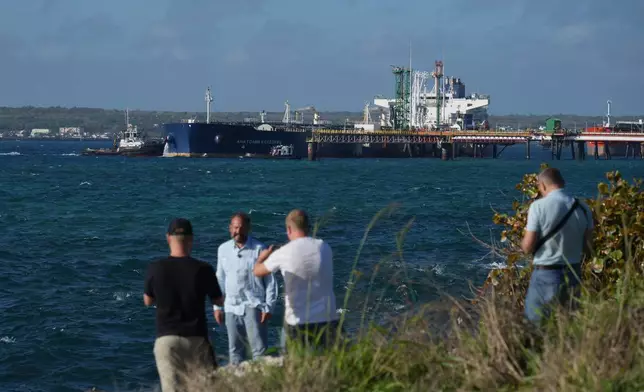 Journalists do a standup in front of the Russian-flagged oil tanker Anatoly Kolodkin docked in Matanzas, Cuba, Tuesday, March 31, 2026. (AP Photo/Ramon Espinosa)