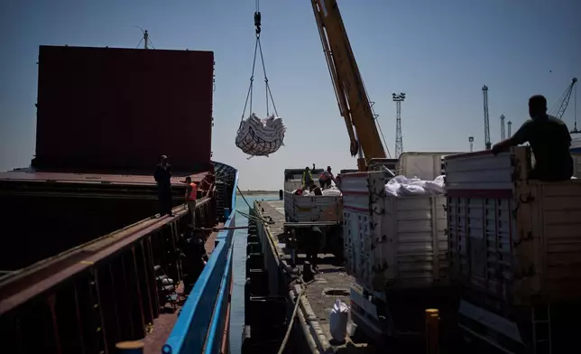 Workers offload cargo of rice from a feeder vessel into trucks at Umm Qasr Port, a deep-water port, in the city of Umm Qasr, Iraq, Friday, March 27, 2026. (AP Photo/Leo Correa)