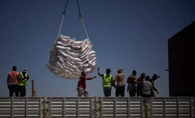 Workers offload cargo of rice from a feeder vessel into trucks at Umm Qasr Port, a deep-water port, in the city of Umm Qasr, Iraq, Friday, March 27, 2026. (AP Photo/Leo Correa)
