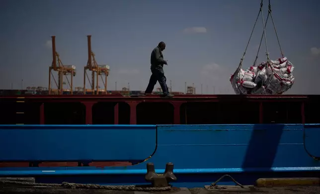 A worker walks on the deck of a feeder vessel as he works to offload cargo of rice into trucks at Umm Qasr Port, a deep-water port, in the city of Umm Qasr, Iraq, Friday, March 27, 2026. (AP Photo/Leo Correa)
