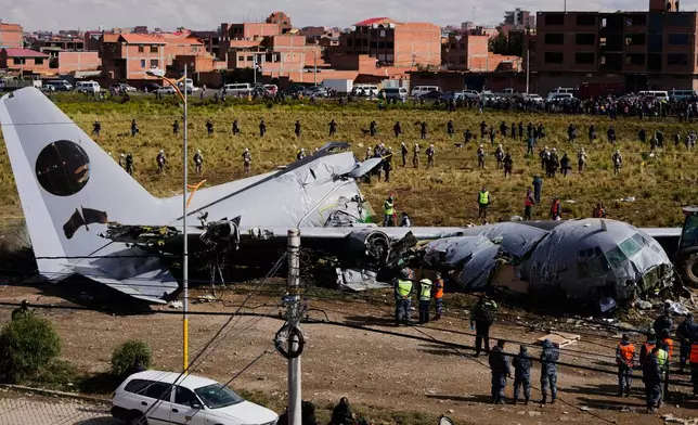 FILE - Military police stand next to a cargo plane that crashed on a highway in El Alto, Bolivia, Feb. 28, 2026. (AP Photo/Juan Karita, File)