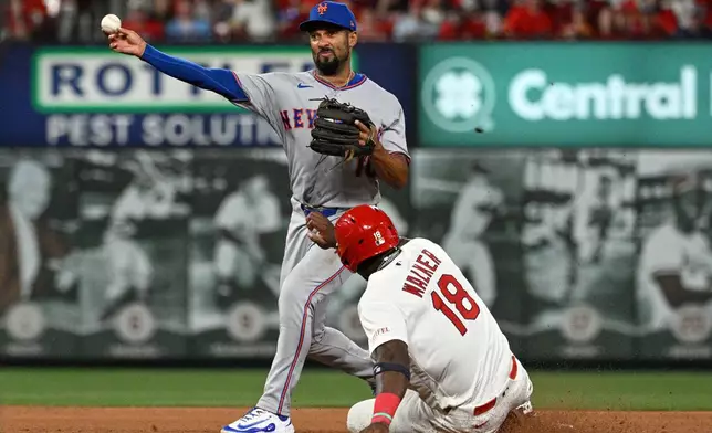 St. Louis Cardinals' Jordan Walker (18), right, is out at second base as New York Mets second baseman Marcus Semien, left, turns a double play in the fourth inning of a baseball game, Monday, March 30, 2026, in St. Louis. (AP Photo/Joe Puetz)