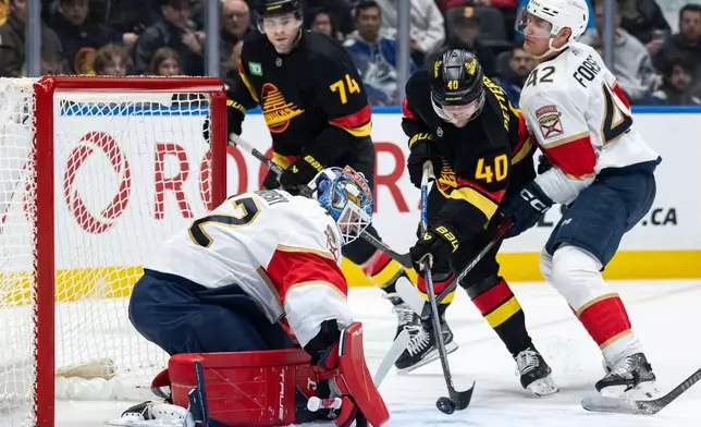 Vancouver Canucks' Elias Pettersson (40) is stopped by Florida Panthers goaltender Sergei Bobrovsky (72) as Gustav Forsling (42) defends during the third period of an NHL hockey game in Vancouver, on Tuesday, March 17, 2026. (Ethan Cairns/The Canadian Press via AP)