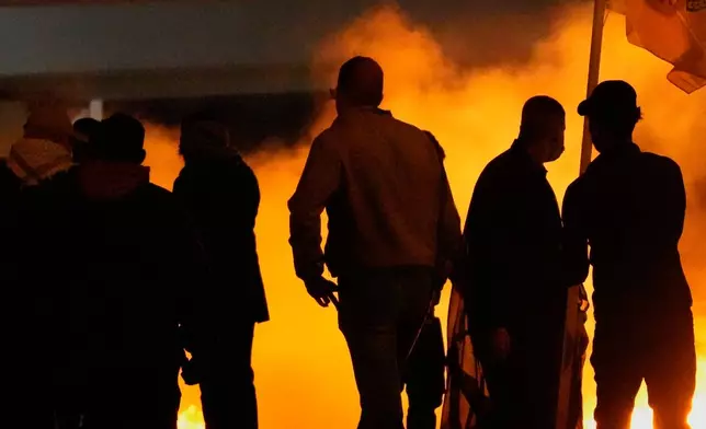 Security forces fire tear gas to disperse a protest against U.S. and Israeli attacks on Iran, at a bridge leading to the fortified Green Zone where the U.S. Embassy is located in Baghdad, Sunday, March 1, 2026. (AP Photo/Hadi Mizban)