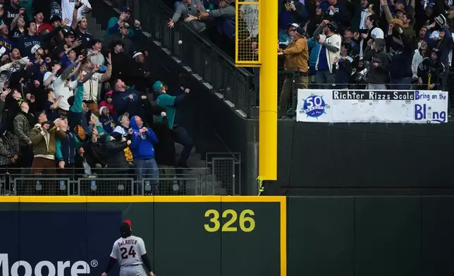 Cleveland Guardians right fielder Chase DeLauter (24) watches the solo home run from Seattle Mariners' Brendan Donovan go over the fence during the first inning of an opening-day baseball game, Thursday, March 26, 2026, in Seattle. (AP Photo/Lindsey Wasson)