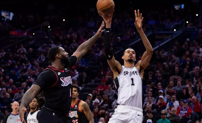 San Antonio Spurs' Victor Wembanyama, right, shoots the ball as he is fouled by Philadelphia 76ers' Andre Drummond during the first half of an NBA basketball game, Tuesday, March 3, 2026, in Philadelphia. (AP Photo/Chris Szagola)