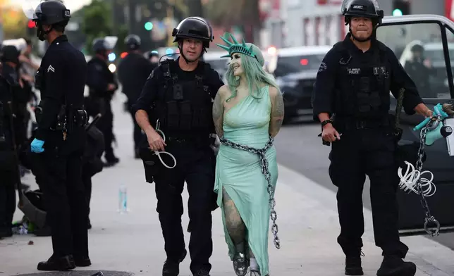Police arrest a protestor dressed as the Statue of Liberty, in downtown Los Angeles after the "No Kings" rally Saturday, March 28, 2026. (AP Photo/Jill Connelly)