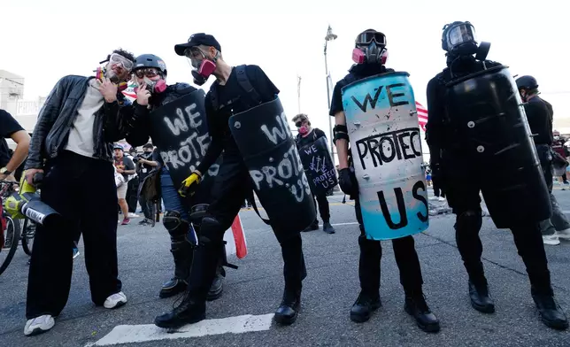 Protestors stand off against police outside the Metropolitan Detention Center in downtown Los Angeles during a "No Kings" rally Saturday, March 28, 2026. (AP Photo/Jill Connelly)