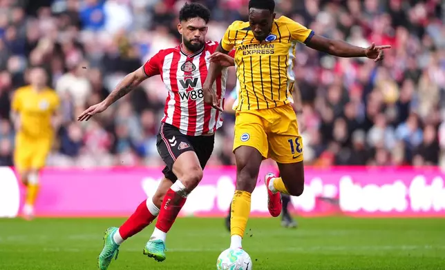 Sunderland's Omar Alderete, left, and Brighton and Hove Albion's Danny Welbeck battle for the ball during the Premier League match in Sunderland, England, Saturday March 14, 2026. (Owen Humphreys/PA via AP)