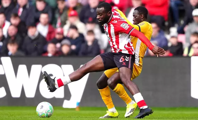 Sunderland's Lutsharel Geertruida, left, and Brighton and Hove Albion's Yankuba Minteh fight for the ball during the Premier League match in Sunderland, England, Saturday March 14, 2026. (Owen Humphreys/PA via AP)