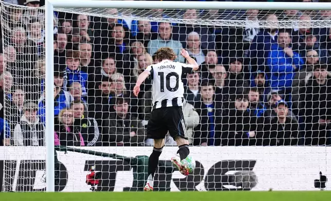 Newcastle United's Anthony Gordon scores their side's first goal of the game during the Premier League match between Chelsea and Newcastle, in London, Saturday March 14, 2026. (John Walton/PA via AP)