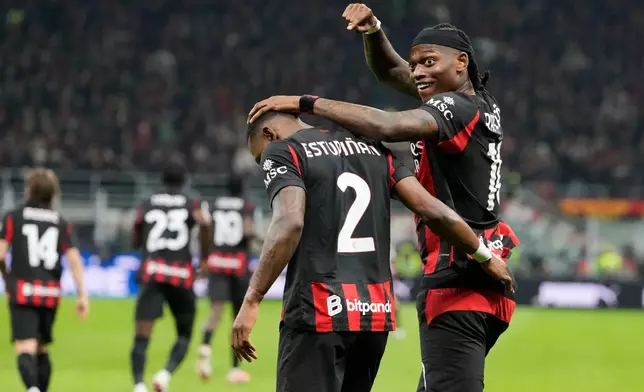 AC Milan's Pervis Estupinan, centre, celebrates with Rafael Leao after scoring the opening goal during the Serie A soccer match between AC Milan and Inter Milan, in Milan, Italy, Sunday, March 8, 2026. (AP Photo/Luca Bruno)