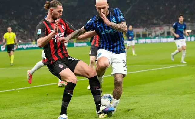 Inter Milan's Federico Dimarco, centre right, and AC Milan's Adrien Rabiot challenge for the ball during the Serie A soccer match between AC Milan and Inter Milan, in Milan, Italy, Sunday, March 8, 2026. (AP Photo/Luca Bruno)