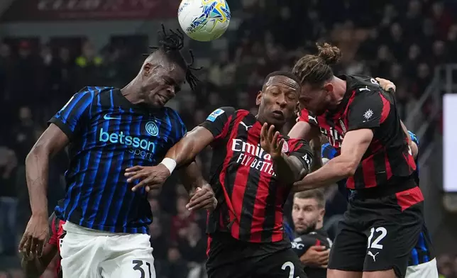 Inter Milan's Yann Bisseck, left, AC Milan's Pervis Estupinan, center, and Adrien Rabiot jump for the ball during the Serie A soccer match between AC Milan and Inter Milan, in Milan, Italy, Sunday, March 8, 2026. (AP Photo/Antonio Calanni)