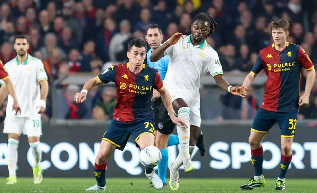 Genoa's Patrizio Masini, center left, fights for the ball with Roma's Evan Ndicka during the Italian Serie A soccer match between Genoa and Roma in Genoa, Italy, Sunday, March 8, 2026. (Tano Pecoraro/LaPresse via AP)