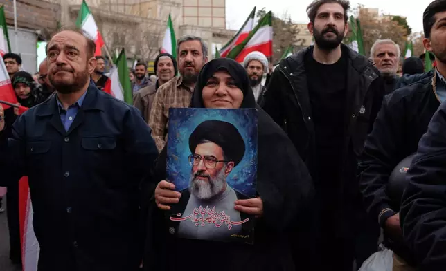 A woman holds a picture of the Iranian Supreme Leader Ayatollah Ali Khamenei during a demonstration in support of the government and against U.S. and Israeli strikes in Tehran, Iran, Saturday, Feb. 28, 2026. (AP Photo/Vahid Salemi)