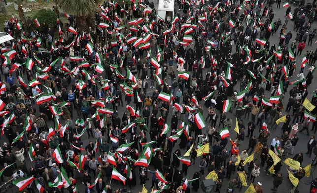 Demonstrators wave Iranian flags in a demonstration in support of the government and against U.S. and Israeli strikes in Tehran, Iran, Saturday, Feb. 28, 2026. (AP Photo/Vahid Salemi)