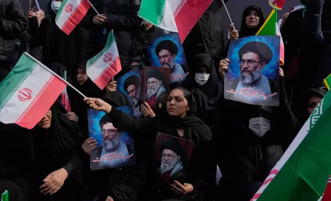 People wave Iranian flags as they hold posters of the late Supreme Leader Ayatollah Ali Khamenei, showing him at different ages, during a rally to support his son Ayatollah Mojtaba Khamenei, who succeeds his father as the new supreme leader, in Tehran, Iran, Monday, March 9, 2026. (AP Photo/Vahid Salemi)