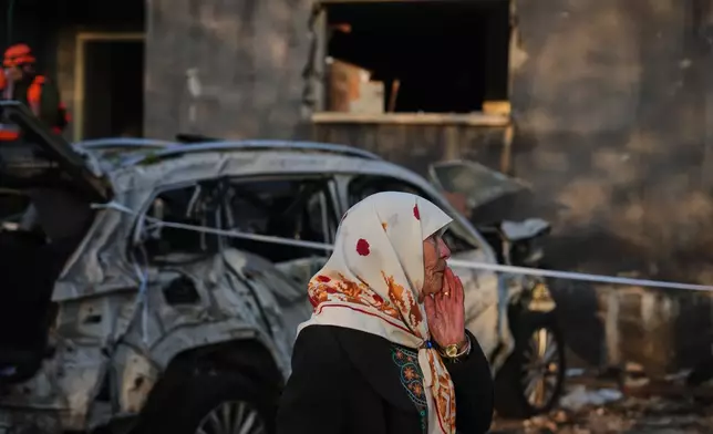 A woman looks at a house destroyed by an Iranian missile strike in Zarzir, northern Israel, Friday, March 13, 2026. (AP Photo/Ariel Schalit)