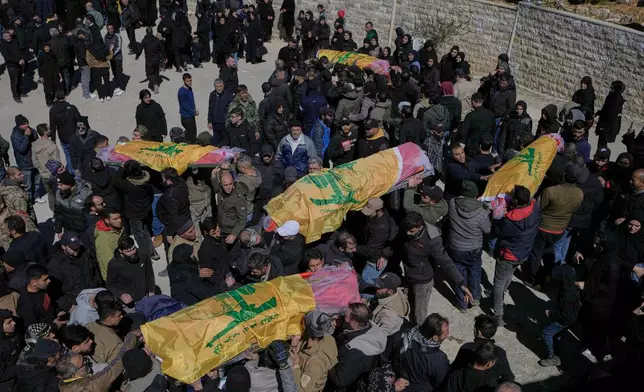 Mourners carry the bodies of Hezbollah fighters who were killed by Israeli airstrikes during their funeral procession in Khraibeh village, eastern Lebanon, Sunday, March 8, 2026. (AP Photo/Bilal Hussein)