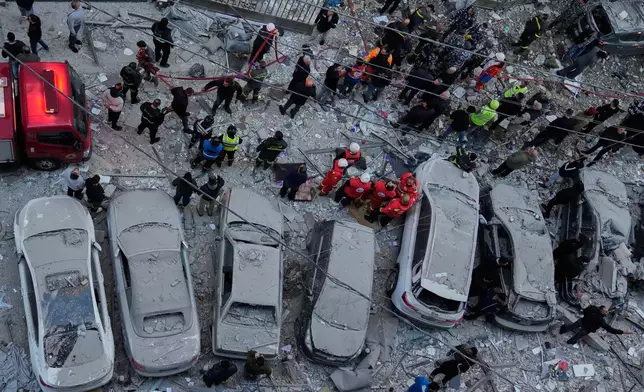 Rescue workers gather at the site where Israeli airstrikes hit apartments in Beirut, Lebanon, Wednesday, March 11, 2026. (AP Photo/Hussein Malla)