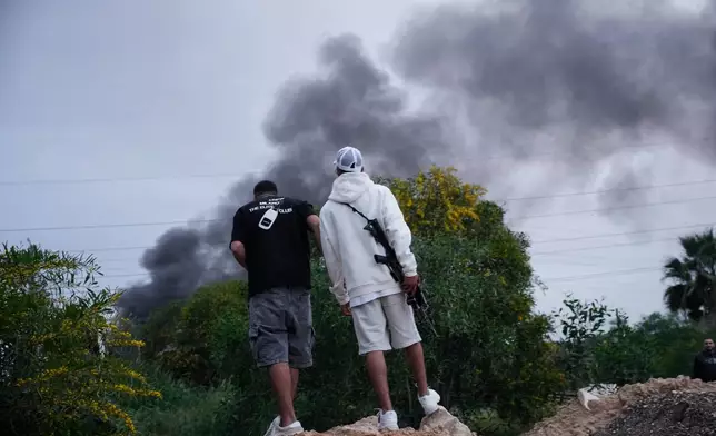 Smoke rises following a direct hit by an Iranian missile strike in Holon, central Israel, Friday, March 13, 2026. (AP Photo/Ohad Zwigenberg)