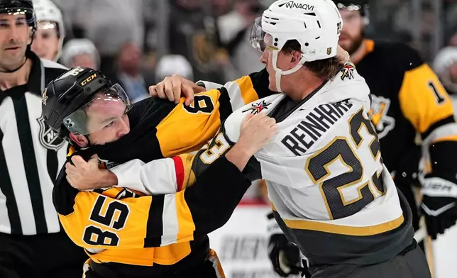 Pittsburgh Penguins' Avery Hayes (85) fights with Vegas Golden Knights' Cole Reinhardt (23) during the second period of an NHL hockey game in Pittsburgh, Sunday, March 1, 2026. (AP Photo/Gene J. Puskar)