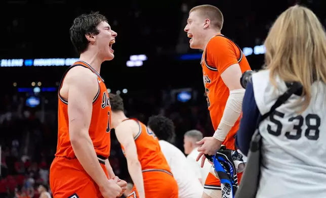 Illinois players celebrate after defeating Houston in the Sweet 16 of the NCAA college basketball tournament Friday, March 27, 2026, in Houston. (AP Photo/Ashley Landis)