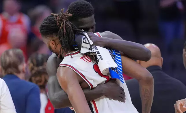 Houston forward Joseph Tugler (11) is embraced by a teammate Kalifa Sakho after losing to Illinois in the Sweet 16 of the NCAA college basketball tournament Friday, March 27, 2026, in Houston. (AP Photo/Eric Gay)