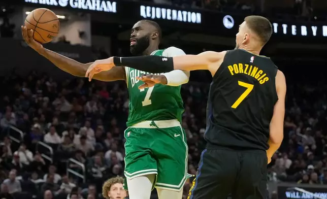Boston Celtics guard Jaylen Brown, left, shoots against Golden State Warriors center Kristaps Porziņģis during the second half of an NBA basketball game in San Francisco, Thursday, Feb. 19, 2026. (AP Photo/Jeff Chiu)