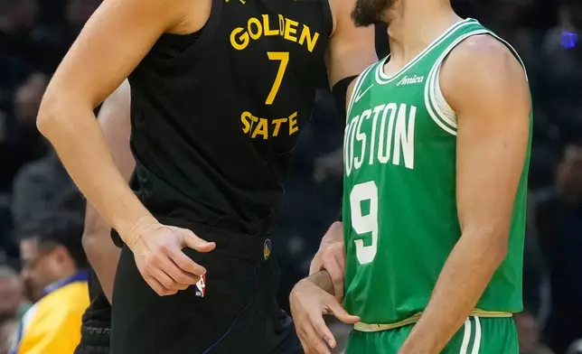 Golden State Warriors center Kristaps Porziņģis (7) talks with Boston Celtics guard Derrick White (9) during the first half of an NBA basketball game in San Francisco, Thursday, Feb. 19, 2026. (AP Photo/Jeff Chiu)