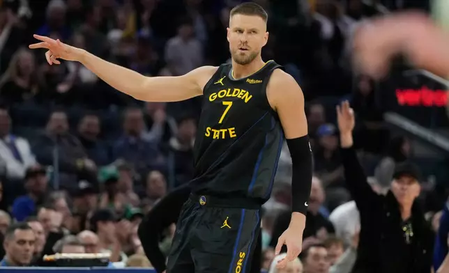 Golden State Warriors center Kristaps Porziņģis (7) gestures after making a 3-point basket during the first half of an NBA basketball game against the Boston Celtics in San Francisco, Thursday, Feb. 19, 2026. (AP Photo/Jeff Chiu)