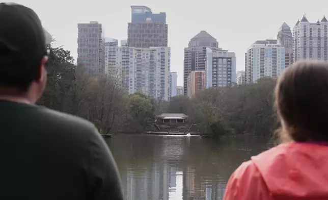 Fernando Coria and Sarah Woolson look at the skyline after screaming in Piedmont Park, Sunday, March 8, 2026, in Atlanta. (AP Photo/Emilie Megnien)