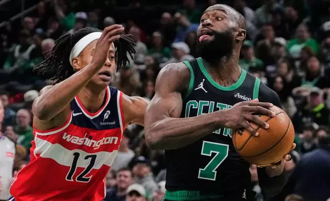 Boston Celtics guard Jaylen Brown (7) drives to the basket past Washington Wizards guard Tre Johnson (12) during the first half of an NBA basketball game, Saturday, March 14, 2026, in Boston. (AP Photo/Charles Krupa)