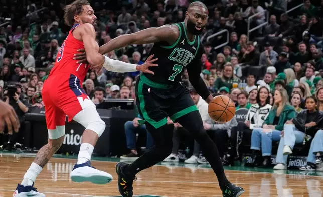 Boston Celtics guard Jaylen Brown (7) drives to the basket past Washington Wizards guard Trae Young, left, during the first half of an NBA basketball game, Saturday, March 14, 2026, in Boston. (AP Photo/Charles Krupa)